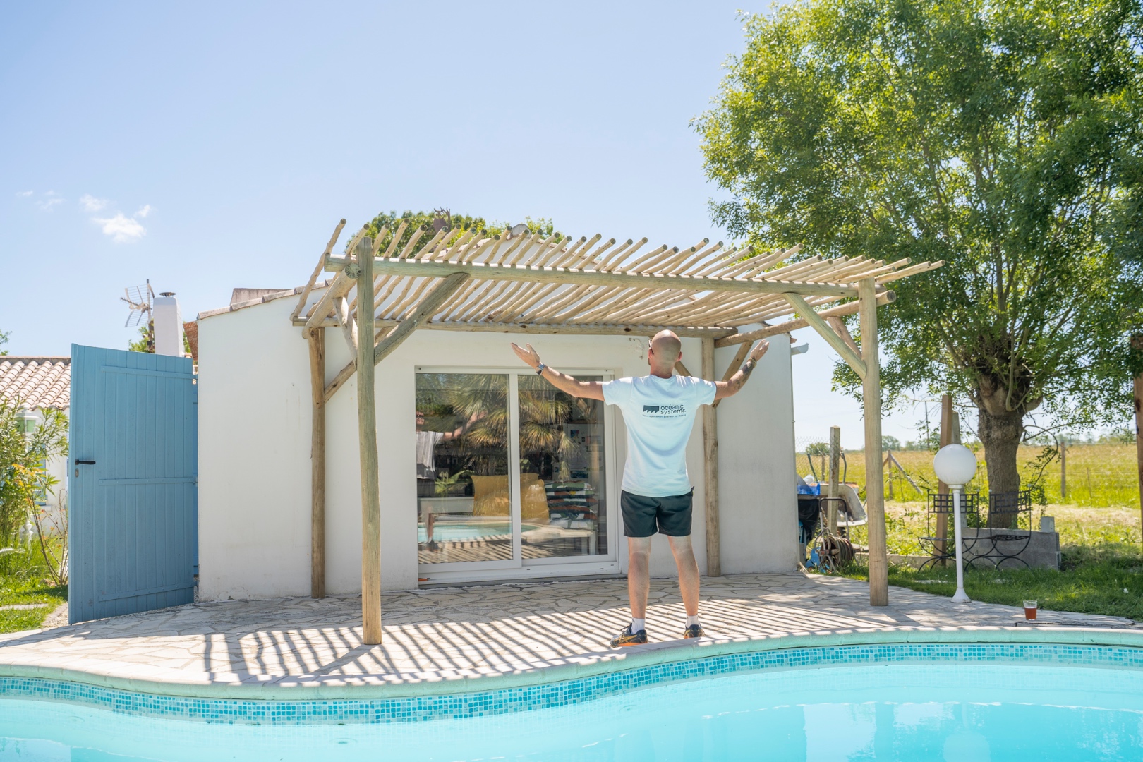 Pergola en bois sur-mesure adossée avec piscine, réalisation Océanic Systems Vendée