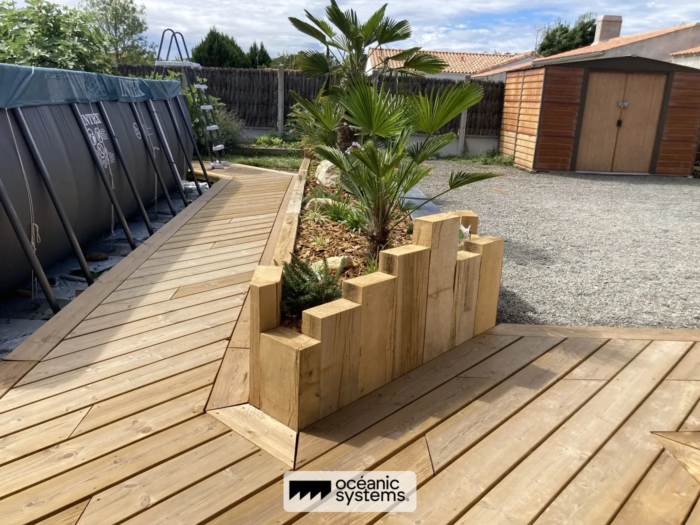 Aménagement bois terrasse avec bac à plantes massif et palmier sur-mesure, Soullans — réalisation Océanic Systems Vendée
